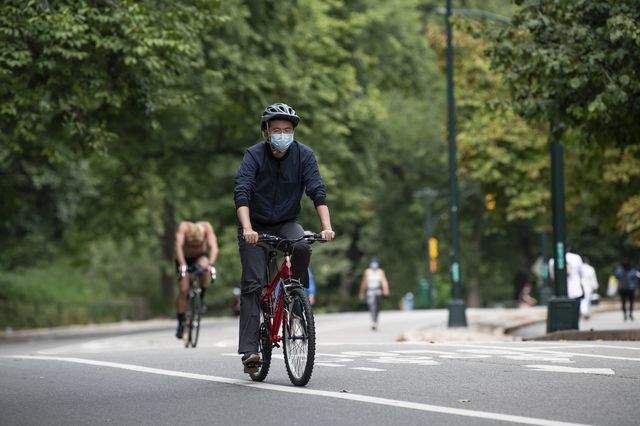 A man wears a mask while bicycling in Central Park